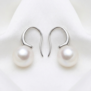A pair of Luna Pearl Silver Hooks with 10mm round freshwater pearls resting on a soft white fabric background.