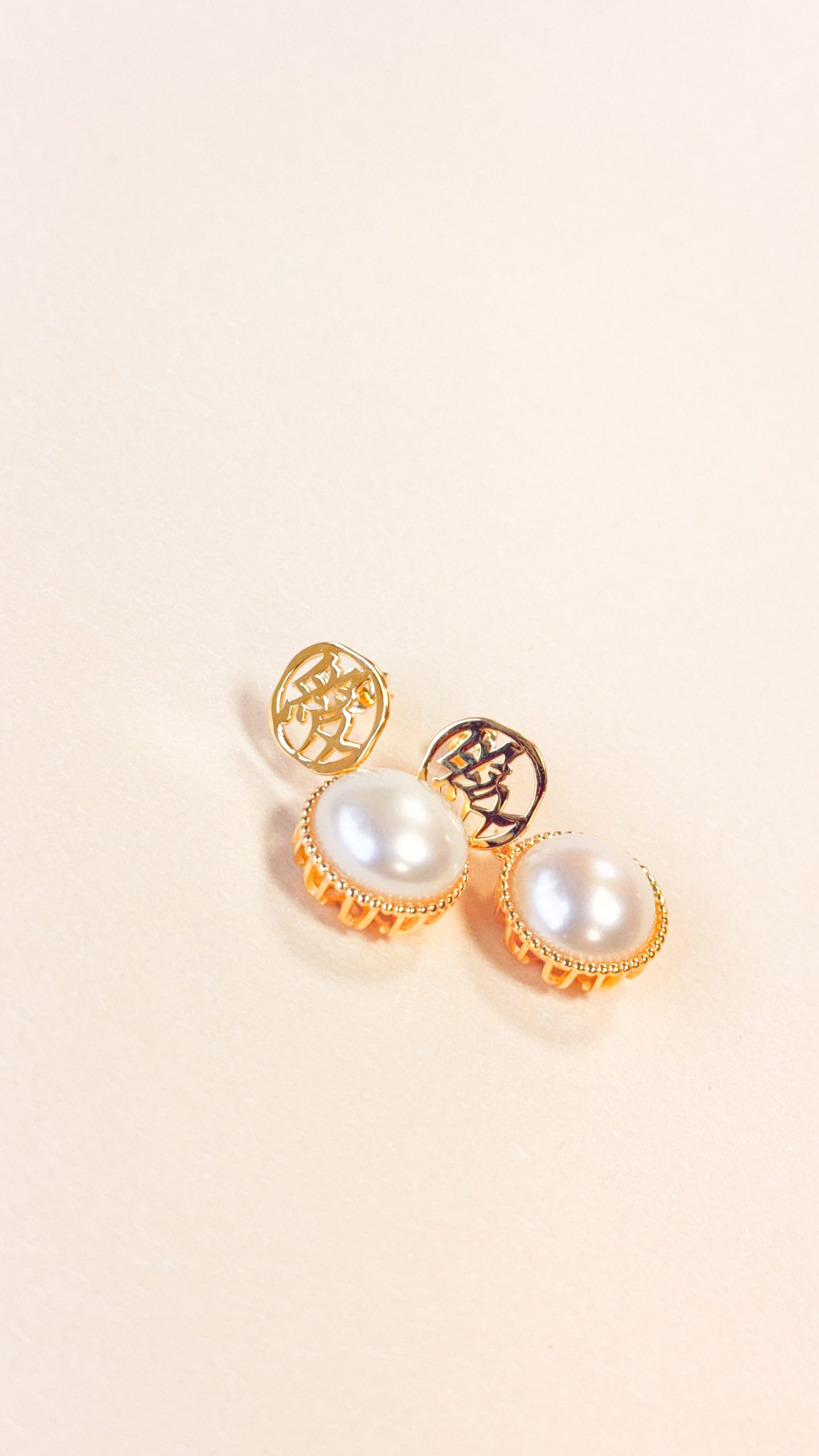 Close-up of the bead-set border and decorative base on the Gold Vermeil Love Character Pearl Earrings.