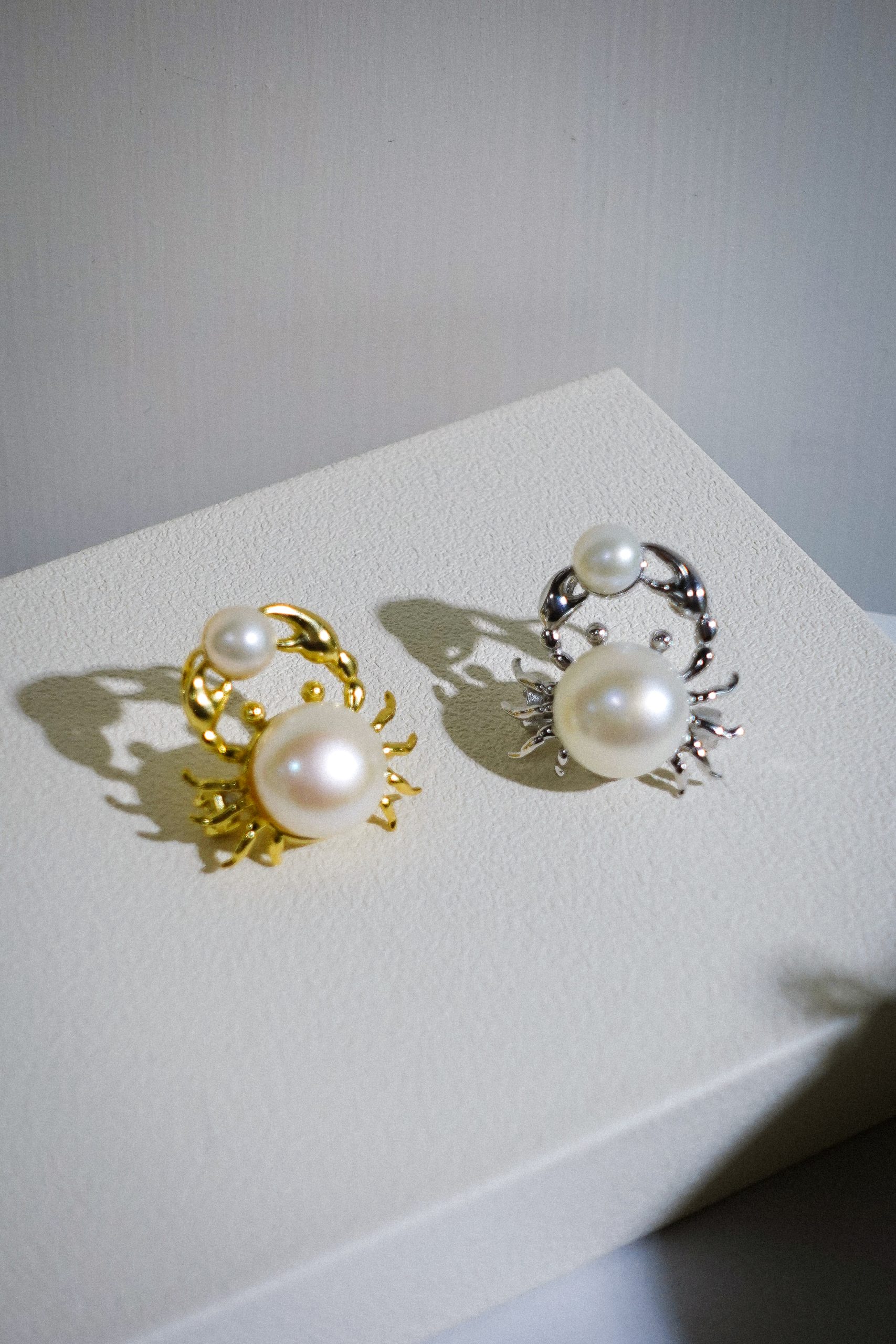 DSC01917 A close-up of the Crab Encounter Pearl Brooch in silver and gold-plated 925 silver, showcasing the large 12mm pearl body and the smaller 6.5mm pearl held in the crab's claws.